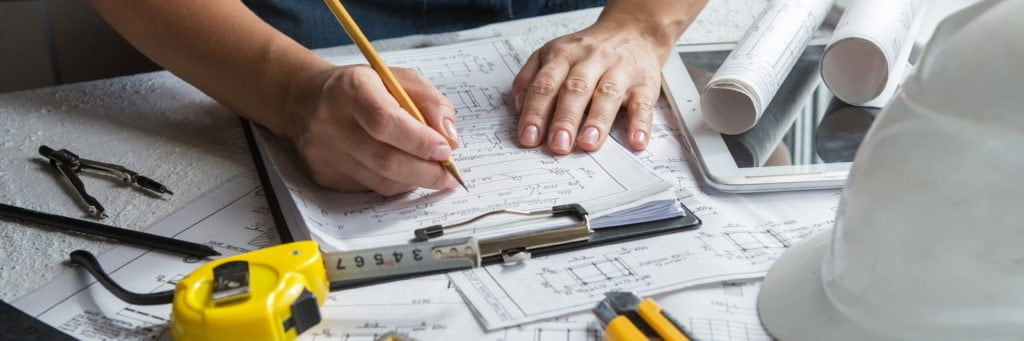 Man writing on blueprints