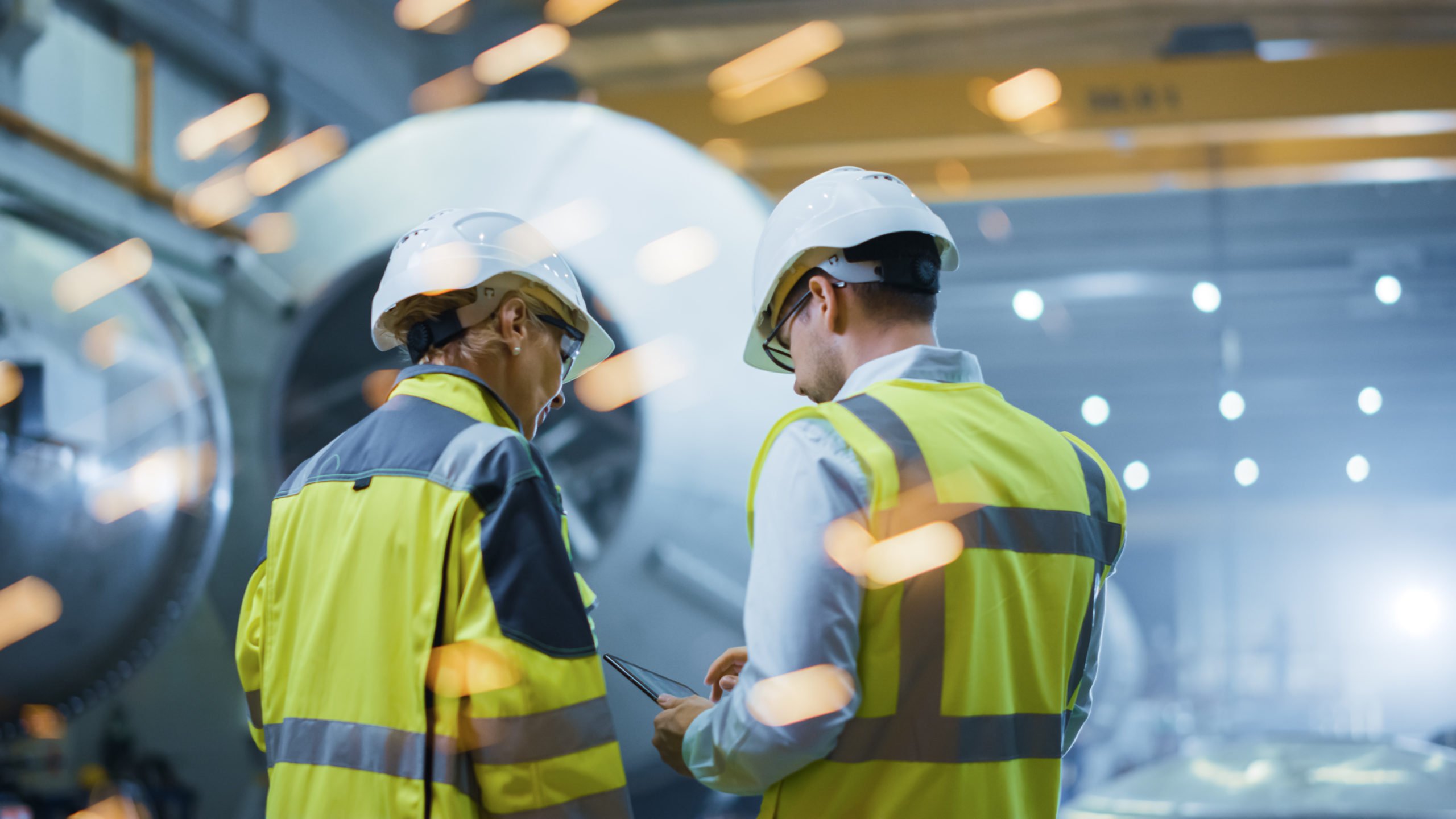 Two Heavy Industry Engineers Stand in Pipe Manufacturing Factory